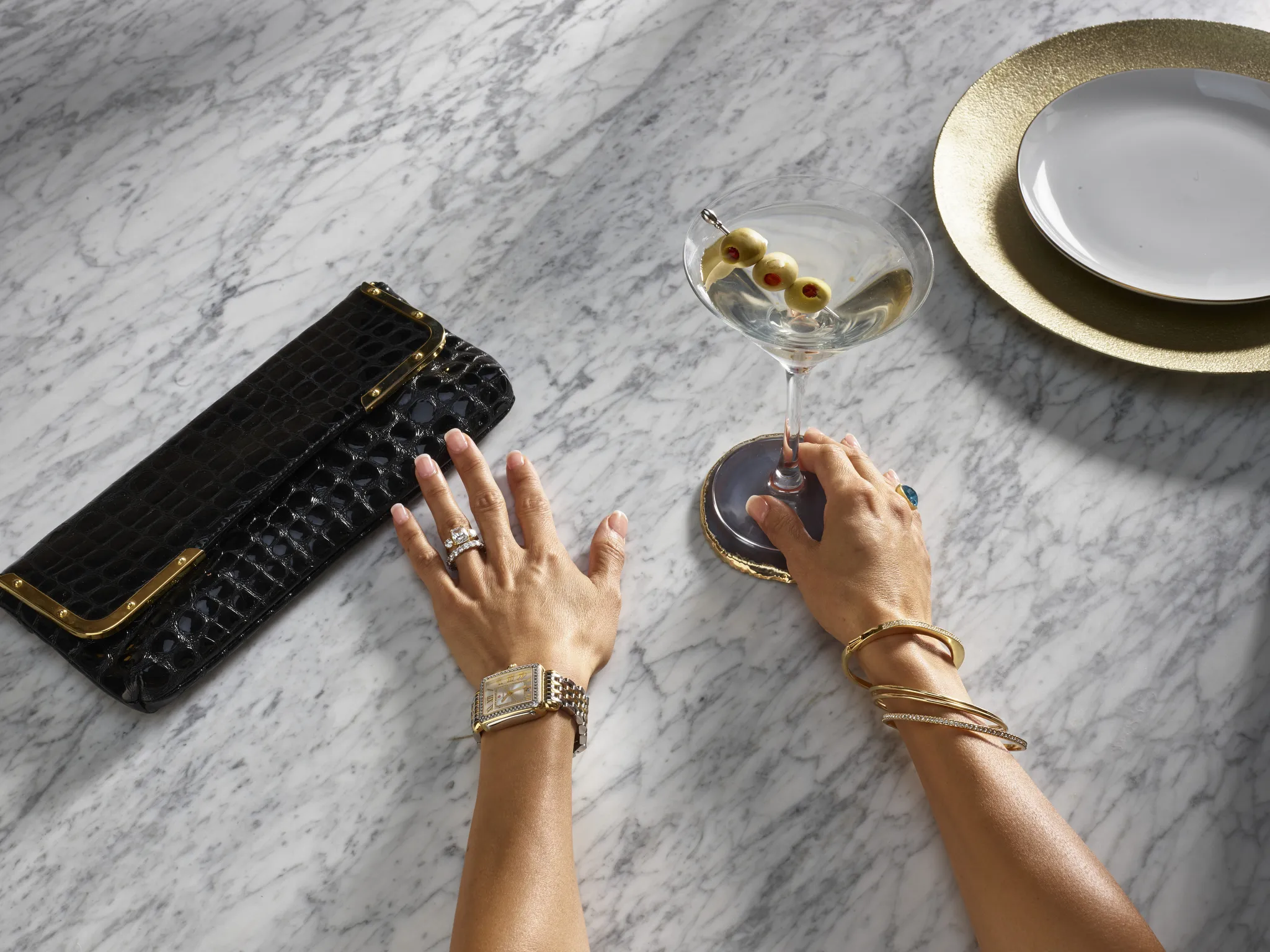 Woman's hands on table with martini cocktail