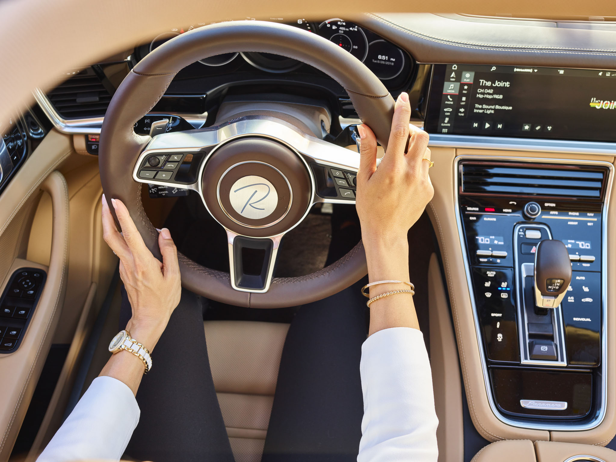 Woman's hands on steering wheel of luxury car